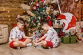 Children in Christmas costumes play near the Christmas tree