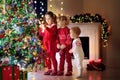 Children at Christmas tree. Kids at fireplace on Xmas eve Royalty Free Stock Photo