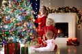Children at Christmas tree. Kids at fireplace on Xmas eve Royalty Free Stock Photo