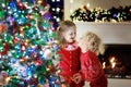 Children at Christmas tree. Kids at fireplace on Xmas eve Royalty Free Stock Photo