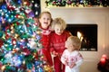 Children at Christmas tree. Kids at fireplace on Xmas eve Royalty Free Stock Photo