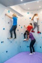 Children climbing special wall and woman helping