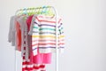 Children clothes on a rack on a light background. Royalty Free Stock Photo