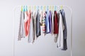 Children clothes on a rack on a light background. Royalty Free Stock Photo