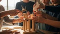 Children collaboratively engage in a woodworking project, using a hammer and glue to construct a structure from wooden blocks Royalty Free Stock Photo