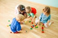 Children collecting toys after playing at kindergarten