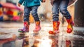 Children with colorful gum boots splashing water in muddy puddles.