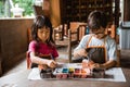 Children coloring clay handicrafts with brushes and paint