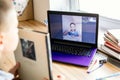 Children communicate online on a computer. The boy shows the book he was reading. The girl approves of his choice