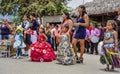 Children compete in a costume contest, with their mothers standing behind them