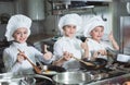 Children cook eggs in the kitchen at the Restaurant.