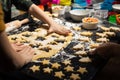 Children cook New Year`s cookies together. Carving Christmas trees and stars out of dough. Preparation for the holiday. Homemade