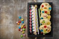 Children cookies with colorful chocolate sweets in sugar glaze on a brown wooden background. Selective focus. Top view. Place