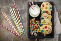 Children cookies with colorful chocolate sweets in sugar glaze on a brown wooden background. Selective focus. Top view. Place