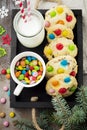 Children cookies with colorful chocolate sweets in sugar glaze on a brown wooden background. Selective focus. Top view. Place