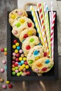 Children cookies with colorful chocolate sweets in sugar glaze on a brown wooden background. Selective focus. Top view. Place