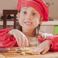 Children cooking. Little funny child girl in chef hat playing with dough and having fun in kitchen Royalty Free Stock Photo