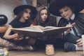 Children in the costumes of monsters with interest consider the spellbook Royalty Free Stock Photo