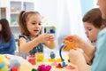 Children creativity. Kids sculpting from clay. Cute little girl mould from plasticine on table in kindergarten Royalty Free Stock Photo