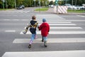 Children cross the road through a pedestrian crossing. Royalty Free Stock Photo