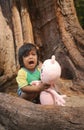 Children crying wearing swimming suit with big tree background