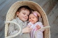 Children, cute little boy 5 years old, with him newborn sister lies in a wicker cradle Royalty Free Stock Photo