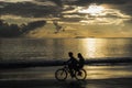 Children cycling on the beach on sunset, Thailand