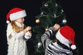 Children decorate the Christmas tree in the room. Royalty Free Stock Photo