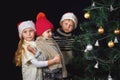 Children decorate the Christmas tree in the room. Royalty Free Stock Photo