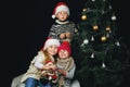 Children decorate the Christmas tree in the room. Royalty Free Stock Photo