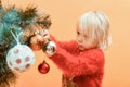 Children decorate the Christmas tree with various toys for the holiday