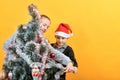 Children decorate the Christmas tree with various toys for the holiday