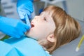 Children dentistry. Liitle girl an dentist examination, teeth cleaning and treatment.