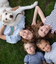 children of different ages, brothers sisters, lie on grass, looking up at camera Royalty Free Stock Photo