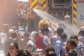 Madrid,Spain,25292022: firefighters throwing water at children in summer on the street at a local festival