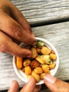 Children with dirty fingers grabbing a nut from a little bowl