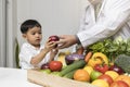 Children and doctors happy to have healthy food.Kid learning about nutrition with doctor to choose eating fresh fruits and Royalty Free Stock Photo