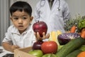 Children and doctors happy to have healthy food.Kid learning about nutrition with doctor to choose eating fresh fruits and Royalty Free Stock Photo