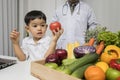 Children and doctors happy to have healthy food.Kid learning about nutrition with doctor to choose eating fresh fruits and Royalty Free Stock Photo