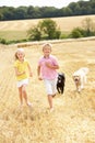 Children With Dogs Running Through Summer Harveste Royalty Free Stock Photo