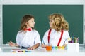 Children doing school lesson at class. Funny school girl an boy pupil drawing a picture. Cute little preschoolers Royalty Free Stock Photo