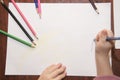 Children draw with colored pencils.