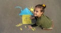 Children draw the Ukrainian flag house on the pavement. Selective focus.