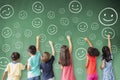 Children drawing emotion face icon on the chalkboard