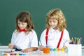 Children in drawing school lesson at class. Funny school girl an boy pupil drawing a picture. Cute little preschoolers Royalty Free Stock Photo