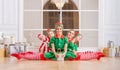 Children dressed in costumes of Christmas elves sitting in twine one after another in front of the mirror in the spacious white