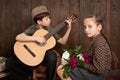 Children are dressed in retro military uniforms sitting and playing guitar, sending a soldier to the army, dark wood background, r Royalty Free Stock Photo