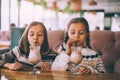 Children drink smoothie in family cafe