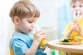 Children drinking juice at nursery or at home Royalty Free Stock Photo