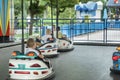 Children drive electric cars in the amusement park. Happy childhood. Theme park. Driving bumper car Royalty Free Stock Photo